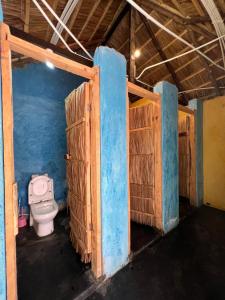 Pokój z niebieskimi ścianami i łazienką z toaletą. w obiekcie Green Garden Guest House w mieście Arusza
