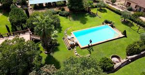 a person standing next to a swimming pool in a yard at La Ermita de los Llanos in Arenas de San Pedro
