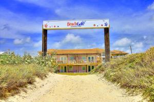 un cartel para un club de playa en la parte superior de un edificio en BeachGate CondoSuites and Oceanfront Resort, en Port Aransas