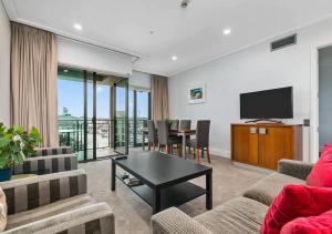 a living room with a television and a table at Sophisticated Spacious APT w Stunning Harbour View in Auckland