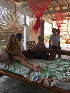 a group of people sitting on a bed at Bohol Hammock Hostel in Batuan