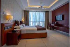 a bedroom with a bed and a desk and a television at AS Inn in Cochin
