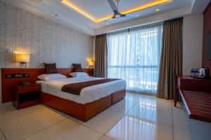 a bedroom with a large bed and a large window at AS Inn in Cochin +88 photos