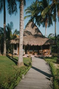uma cabana com uma palmeira e uma passagem em Le Nusa Beach Club em Nusa Lembongan