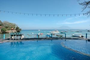uma grande piscina ao lado de um corpo de água em Le Nusa Beach Club em Nusa Lembongan