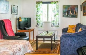 sala de estar con TV, 2 sillas y mesa en Pet Friendly Home In Slite With Kitchen, en Gothem