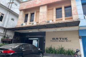 une voiture noire garée devant un bâtiment dans l'établissement OYO 92342 Hotel Batik Traveller, à Medan