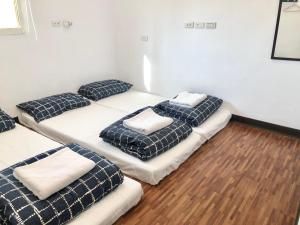 a room with four beds with pillows on them at 不倒翁輕旅 in Hsi-kuo-shan