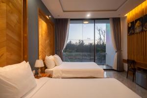 a hotel room with two beds and a window at Khách sạn gần biển Karina Phú Yên in Liên Trì (4)