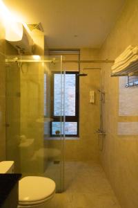 a bathroom with a glass shower and a toilet at Khách sạn gần biển Karina Phú Yên in Liên Trì (4)