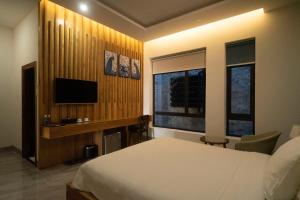 a bedroom with a bed and a television in it at Khách sạn gần biển Karina Phú Yên in Liên Trì (4)