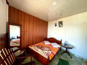 a bedroom with a bed and a table and two chairs at Lakshan View Resort in Haputale