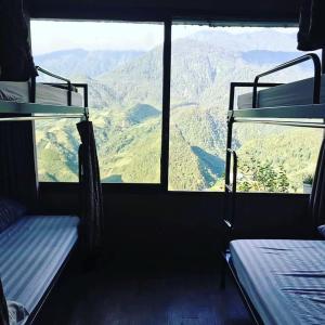 a room with two bunk beds and a view of mountains at Fansipan Terrace Cafe and Homestay in Sa Pa