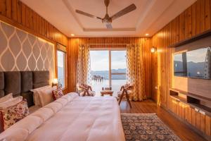 um quarto com uma cama grande e uma janela grande em Wilderness Whisperings with Himalayan View em Nainital