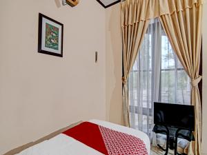 a bedroom with a bed and a window with a television at OYO 92330 Hotel Rindu Sempadan in Pekanbaru