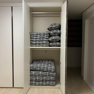 um closet cheio de toalhas cinzentas e brancas em Sanwol Guesthouse em Gwangju
