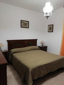 1 dormitorio con cama y lámpara de araña en Stanais, en Tortolì