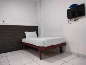 a bedroom with a bed and a tv on a wall at Kings Fort Rooms Thrippunithura in Ernakulam