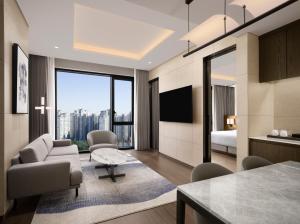 a living room with a bed and a living room with a tv at Four Points by Sheraton Suwon in Suwon
