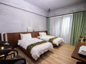 a hotel room with two beds and a table at 48-6 Homestay in Xincheng