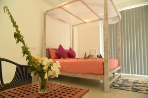 ベントータにあるEldezo Relax Paradise (Pvt) Ltdのベッドルーム1室(花瓶のあるテーブル付)