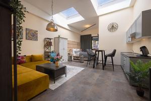 a living room with a yellow couch and a kitchen at Fabric Apartments in Dettingen an der Erms