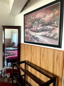 a painting on the wall of a room with a table at Lakshan View Resort in Haputale
