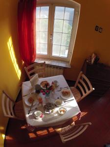 une table avec une assiette de nourriture et une fenêtre dans l'établissement B&B Il Cedro, à Gênes