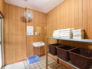 a bathroom with a sink and a shelf with towels at Misaki Kanko Hotel in Muroto