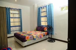 - une chambre avec un lit et un ventilateur de sol dans l'établissement Camiguin Island Retreat, 