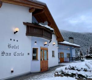 un bâtiment dans les montagnes avec de la neige au sol dans l'établissement Hotel San Carlo, tra Bormio e Livigno, à Valdidentro