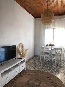 a living room with a tv and a dining room table at Casa Yasmina in Katastárion