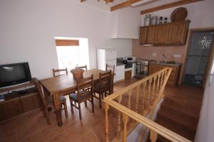 uma cozinha e sala de jantar com uma mesa de madeira e cadeiras em Homepico em Arcos