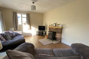 sala de estar con sofá y chimenea en Cheerful 3 bedroom bungalow with indoor fire place, en Gloucester