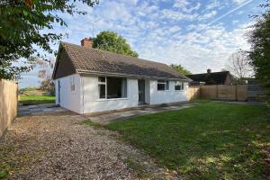 a small white house in a yard at Cheerful 3 bedroom bungalow with indoor fire place in Gloucester