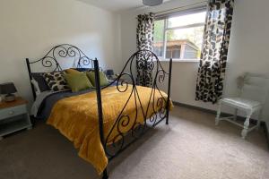 1 dormitorio con cama negra y ventana en Cheerful 3 bedroom bungalow with indoor fire place, en Gloucester