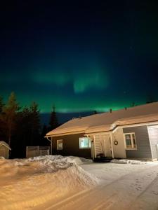una casa con las verdes luces del norte en el cielo en House Venni, en Rovaniemi