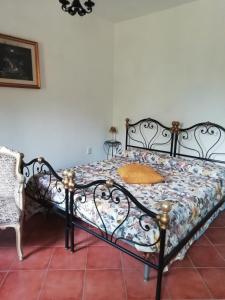 1 dormitorio con 1 cama en blanco y negro y 1 silla en Stanais, en Tortolì