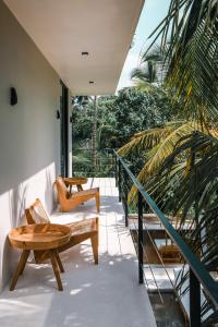 patio con mesa de madera y sillas en el balcón en Terra Villas, en Ahangama