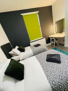 two beds in a room with a green wall at Luxury home in Anfield in Liverpool