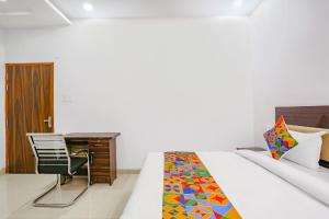 a bedroom with a bed and a desk and a chair at FabHotel KS Grand in Kānpur