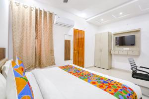 a bedroom with a bed and a television in it at FabHotel KS Grand in Kānpur