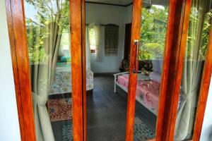 a glass door to a room with a bedroom at Sumatra Orangutan Discovery Villa in Bukit Lawang
