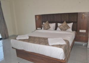 1 dormitorio con 1 cama grande y 2 toallas. en Hotel Brilliant Panchgani en Pānchgani