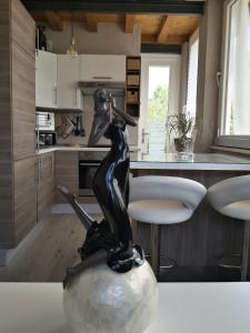 Eine Statue einer Frau, die in einer Küche auf einem Ball sitzt. in der Unterkunft Note di lago in Manerba del Garda
