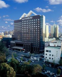 a large building with a sign on it in a city at Beijing Changbaishan International Hotel in Beijing