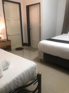 una camera d'albergo con due letti e una porta di Y&N House a Prachuap Khiri Khan