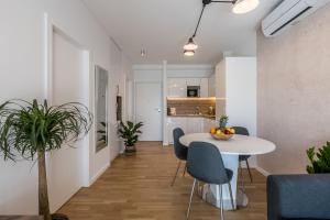 斯普利特6 Islands - Holiday & Business Apartments - free garage parking的一间带桌椅的客厅和一间厨房 更多31张照片