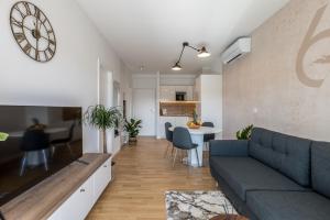 a living room with a blue couch and a kitchen at 6 Islands - Holiday & Business Apartments - free garage parking in Split