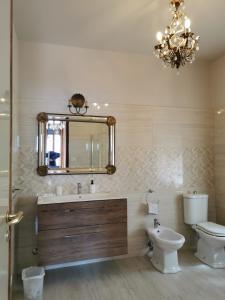 a bathroom with a sink and a toilet and a mirror at Villa Sara in Taormina